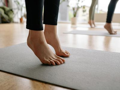 Close-up of feet on a yoga mat, showing balance and stability.